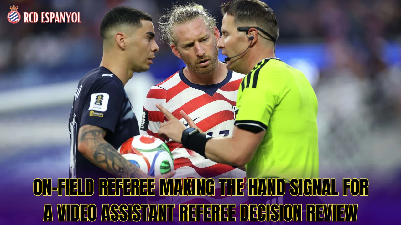 On-field referee making the hand signal for a Video Assistant Referee decision review